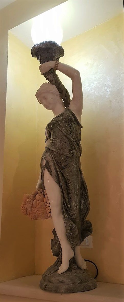 A statue of a woman holding a child, standing on a pedestal.