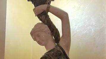 A statue of a woman holding a child, standing on a pedestal.