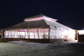 A large, white tent with a peaked roof and a balcony, set in a snowy environment. - Dynasty Desert Camp (Jaisalmer)