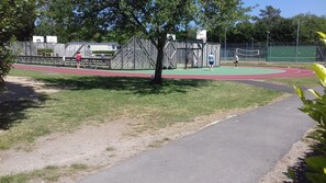 A sports facility with a running track, basketball courts, and a fenced area. - Mobil home au calme (Pont-Aven)