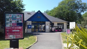 A blue building with a reception area and a sign indicating a mobile home rental service.