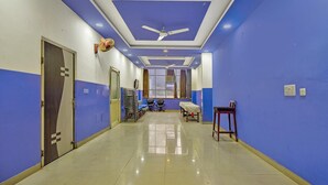 Un couloir aux murs bleus, doté d’un ventilateur de plafond et d’un sol carrelé.