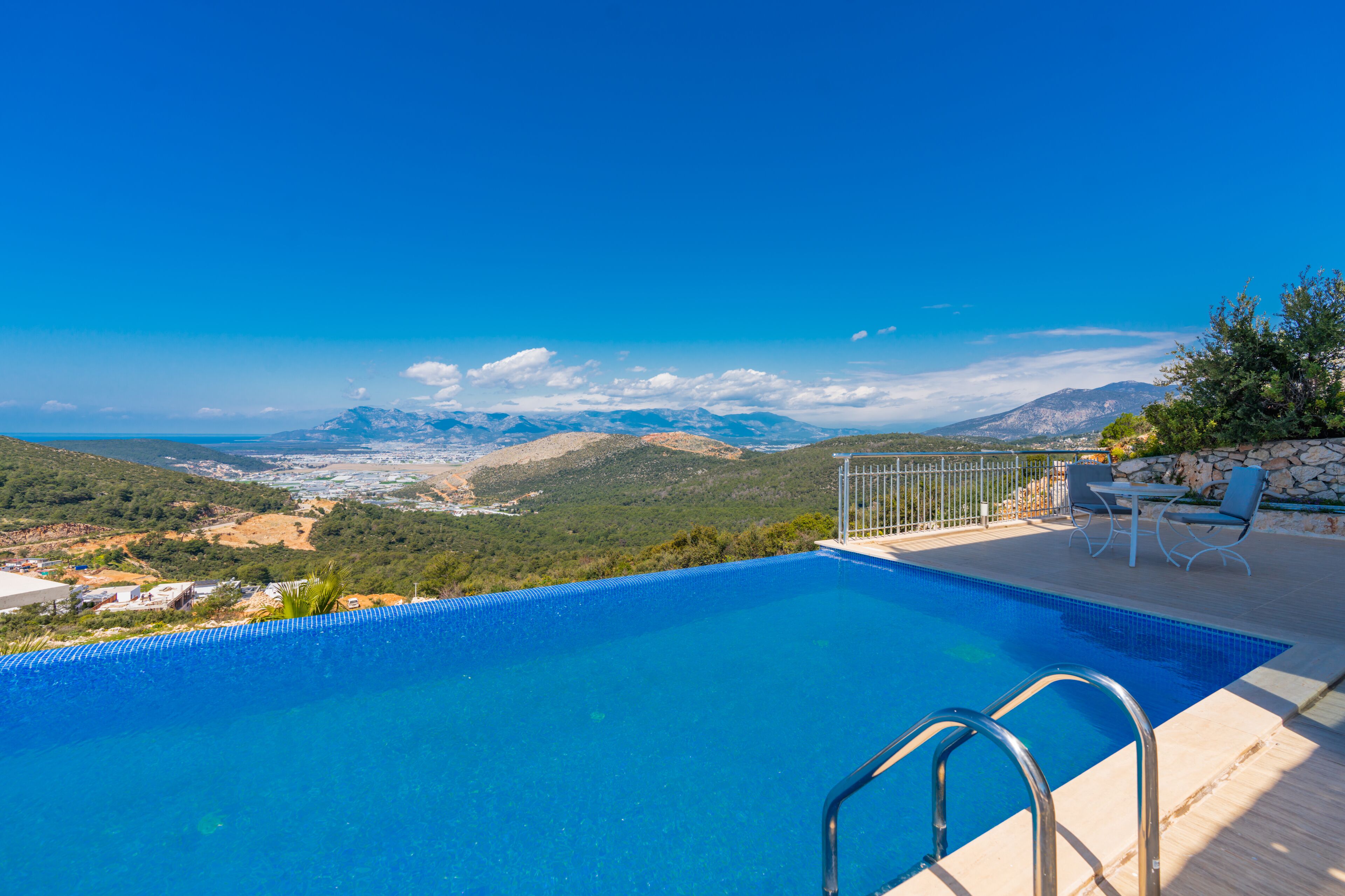 Ein Pool mit Blick auf Berge und eine ferne Stadt.