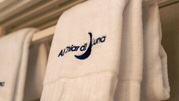 A white towel with the logo "Alitalia del Luna" hanging on a rack.