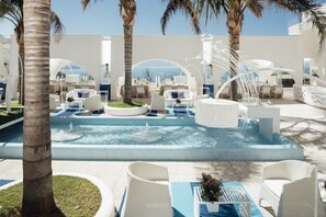A pool area with lounge chairs and a hot tub, surrounded by palm trees and white architecture. - Al Chiar di Luna (Monte di Procida)
