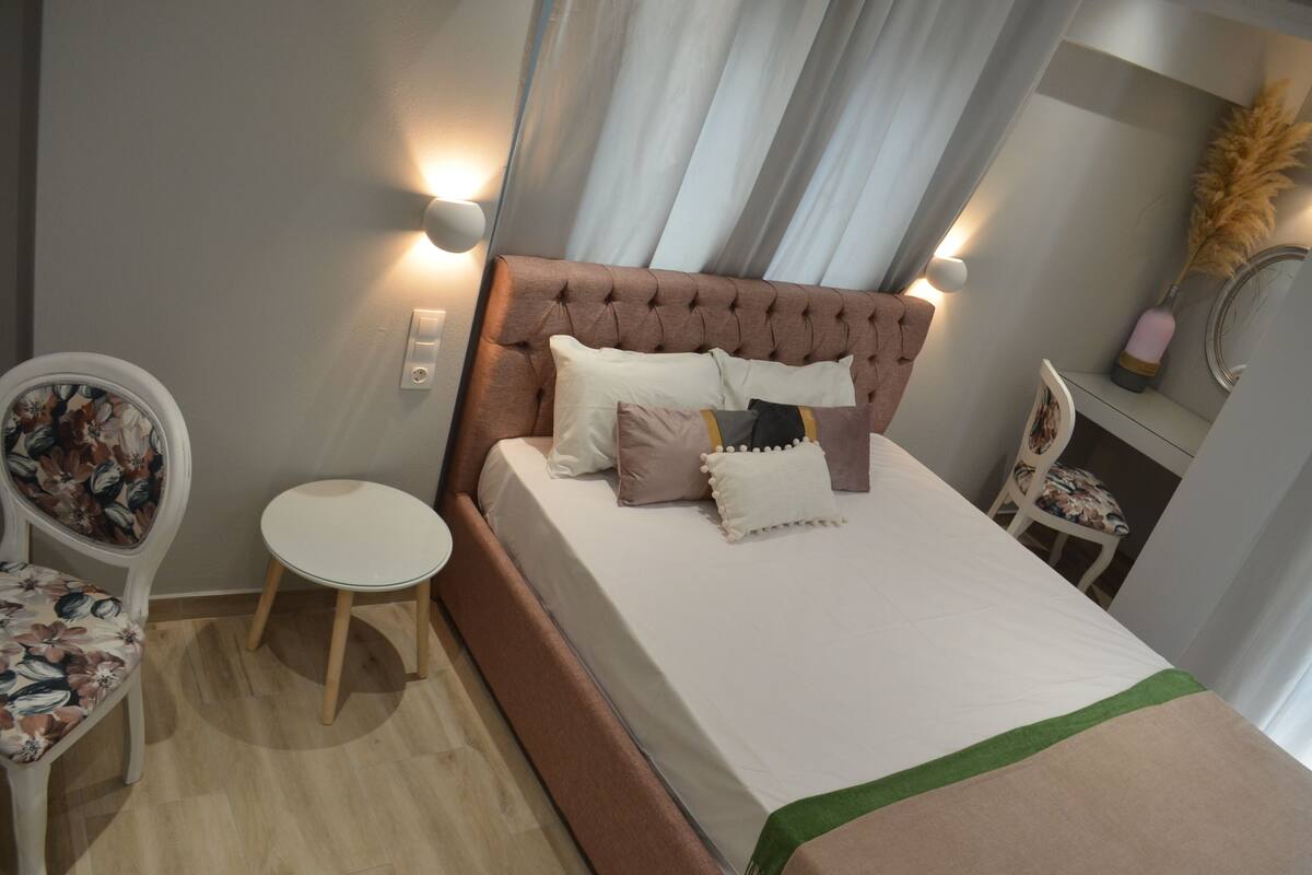 A neatly arranged bedroom with a bed, a small round table, and a chair.