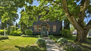 A two-story house with a front porch, surrounded by well-maintained lawns and trees. - Walk to Dtwn Shops & Eats: Sturgeon Bay Retreat (Sturgeon Bay)