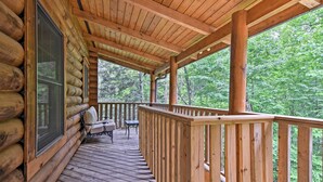 A wooden deck with a railing, a grill, and a table. - Family Friendly! Linville Cabin w/ Wraparound Deck (Linville)
