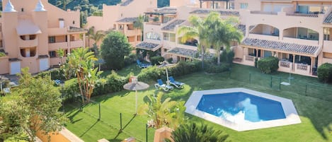 A resort with multiple buildings, a swimming pool, and well-maintained lawns.