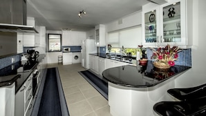 A modern kitchen with white cabinetry, a black countertop island, and a built-in wine rack.