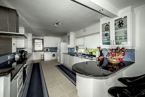 Enjoy cooking in this well-lit kitchen with a central island, sink, and stainless steel range hood.