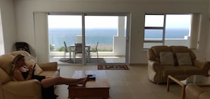 Relax in this ocean-view living room with a sofa, armchair, and coffee table, perfect for unwinding.