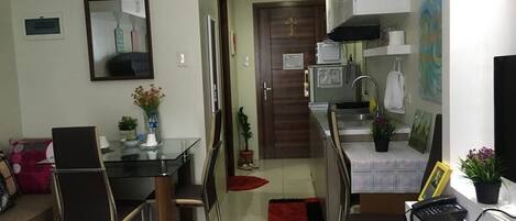 A compact living space with a dining area, kitchenette, and a small hallway.
