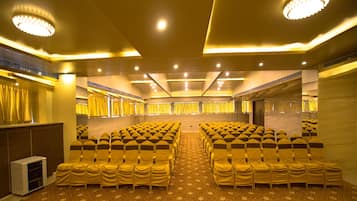 A conference room with rows of chairs, a podium, and a patterned carpet.
