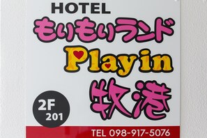 Placa de hotel com o nome 'Hotel Playin' e um número de telefone.