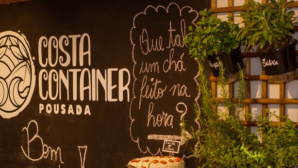A dessert display at Costa Container Pousada with various cakes and pastries.