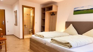 A bedroom with a wooden bed, a wardrobe, a desk, and a painting on the wall. - Gasthof Altmann (Eschlkam)
