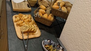 A buffet setup with various food items, including bread, pastries, and condiments. - Gasthof Altmann (Eschlkam)