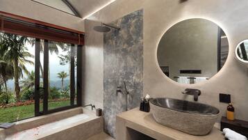 A modern bathroom with a large window, a stone sink, and a shower.