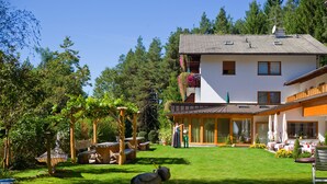 Una casa con jardín, un columpio y una gran escultura de pájaro.