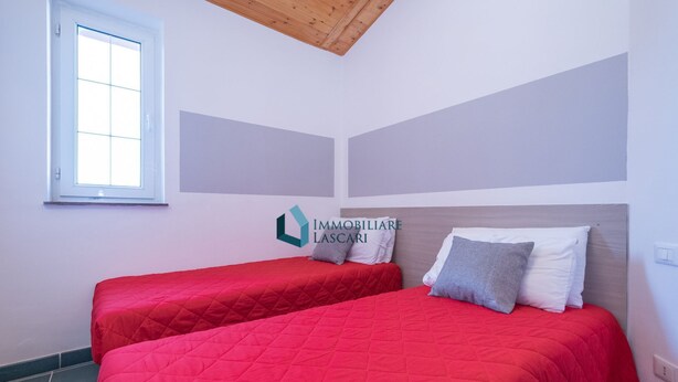 Une chambre avec deux lits, une fenêtre et un logo sur le mur.