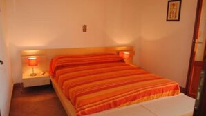 A small, single-bed room with a wooden headboard and two bedside lamps. - Country Cottage / Gite - Campofelice di roccella (Campofelice di Roccella)