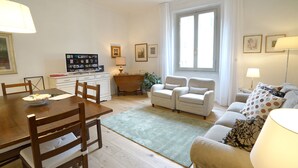 En lys stue med spiseplads, et badekar og et stort vindue, der giver naturligt lys.