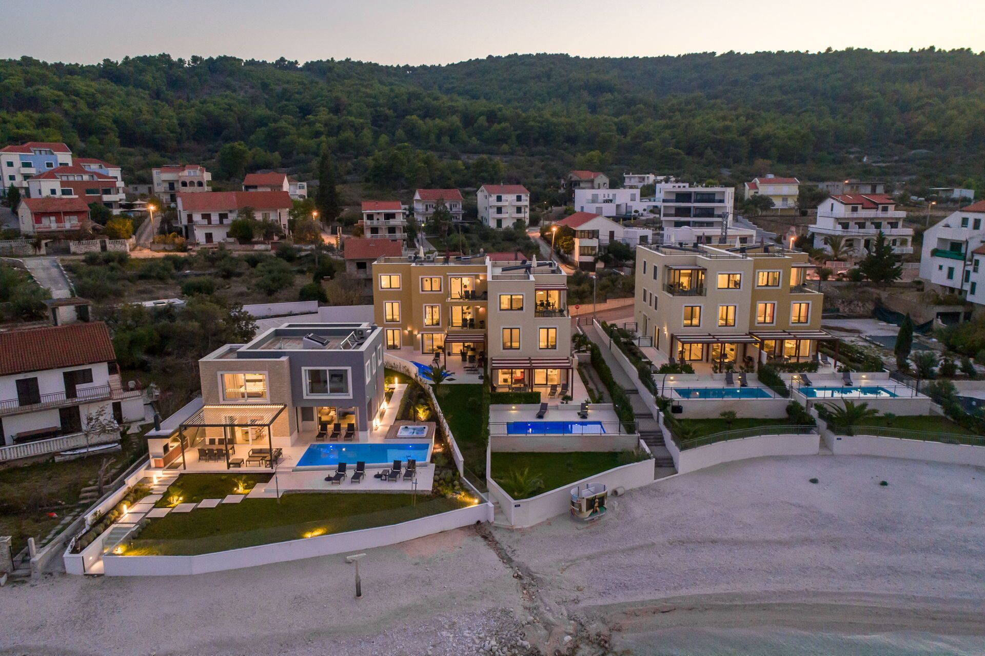 A modern residential complex with multiple buildings, a swimming pool, and a landscaped garden.
