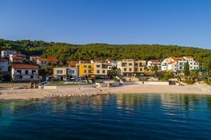 A coastal town with colorful buildings, a sandy beach, and a clear blue sea.