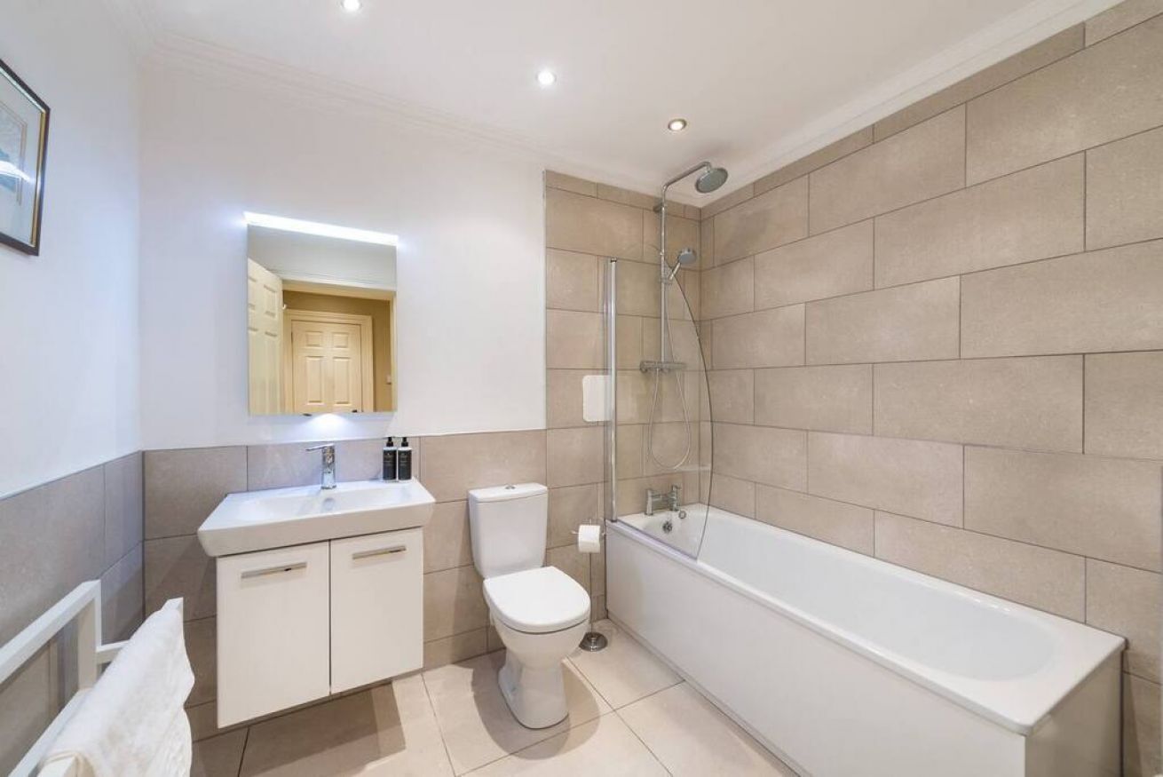 A modern bathroom with a white sink, toilet, and bathtub.