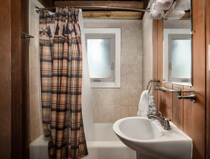 Banyera, assecador de cabells, tovalloles i paper higiènic 