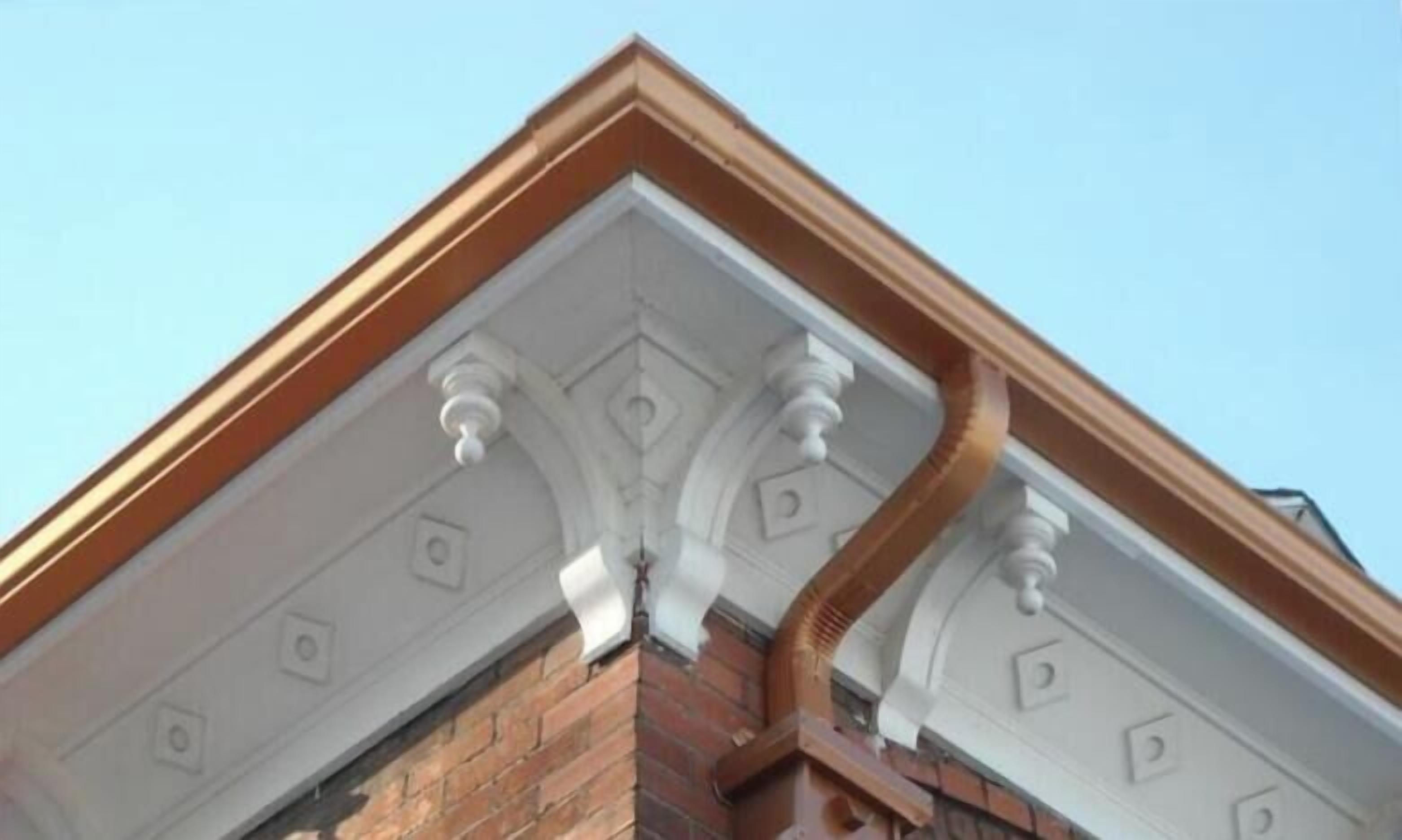 A corner of a building with a brick facade and white decorative moldings.