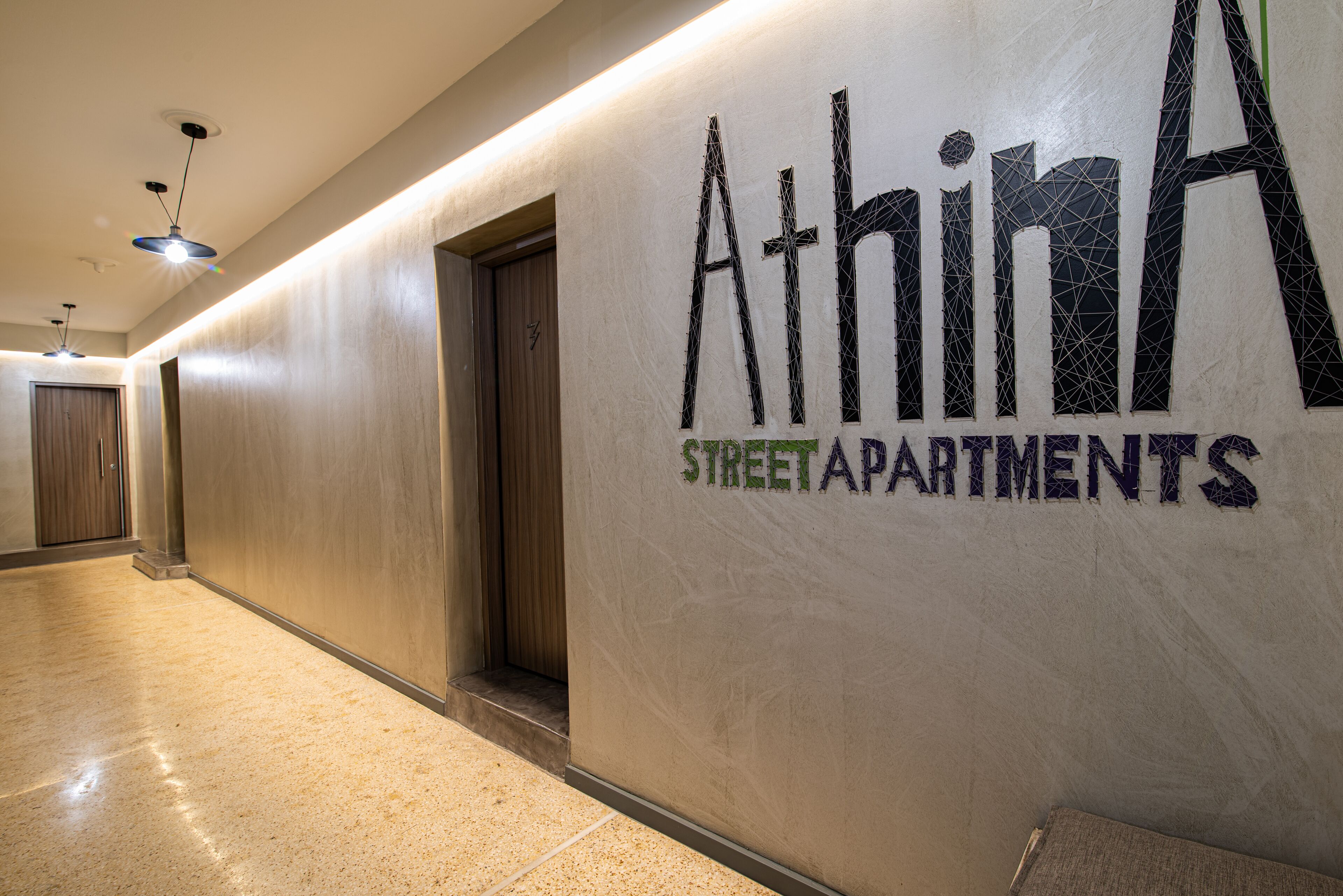 A hallway with a sign for 'Athina Street Apartments'.