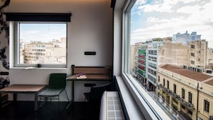 A modern room with a large window, a desk, a chair, and a radiator. - AthinA STREETAPARTMENTS (Athens)