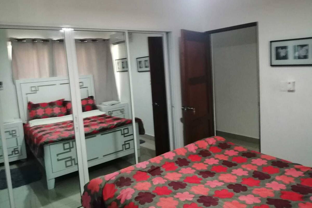 Quarto com cama, guarda-roupa, escrivaninha e cadeira.