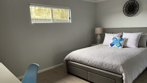 A bedroom with a bed, a desk, a chair, a window, and a wall-mounted light fixture. - SeaEsta@Culburra- 3min walk to the Beach or Curleys Bay (Culburra Beach)