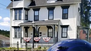A two-story house with a porch and American flags.