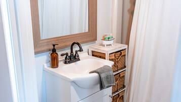 Een bad/douchecombinatie, een haardroger, handdoeken, zeep