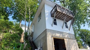 A two-story house with a balcony on the upper floor. - Large Cottage:  Private Beach/Stunning Sunsets/Kayaks/Fire Pit (Swanton)
