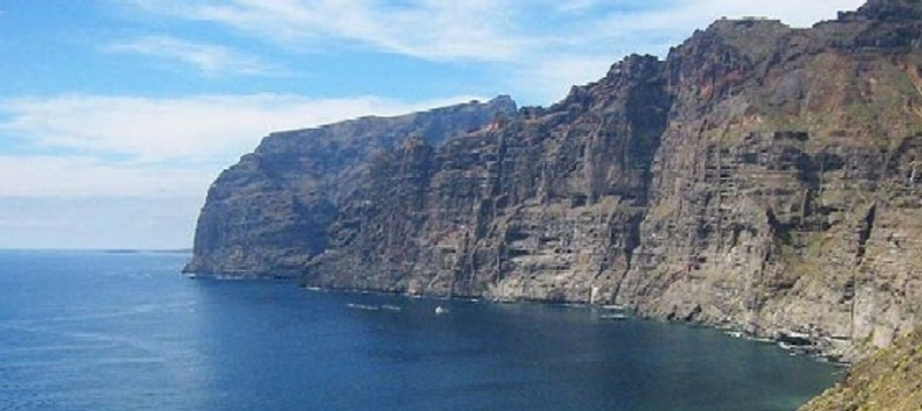 Une falaise côtière au relief accidenté, offrant une vue dégagée sur la mer.
