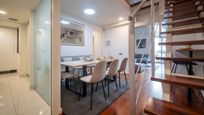 A modern interior with a dining area, a staircase, and a view of the outside. - Four bedroom apartment Ronda Sant Pere - You Stylish (Barcelona)