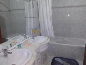 Een bad/douchecombinatie, een haardroger, een bidet, handdoeken