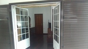 A room with a wooden door, a small cabinet, and a lamp. - Happy group or large family holiday - Free Wifi (Felgueiras)