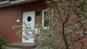 A brick house with a white door and a small porch.