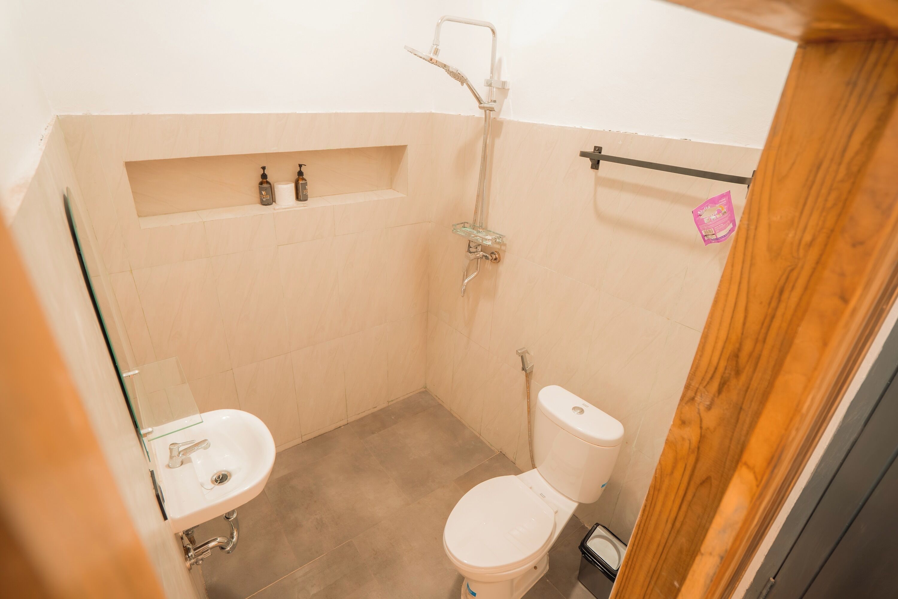 A small bathroom with a toilet, a glass shower enclosure, and a sink.