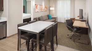 A hotel room with a dining table, a sofa, a TV, and a desk. - Residence Inn by Marriott Ontario Rancho Cucamonga (Rancho Cucamonga)