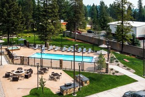 A pool area with lounge chairs and a barbecue setup.