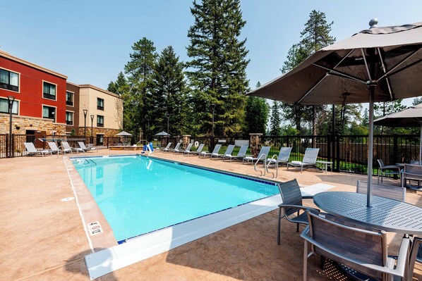 Alberca al aire libre, sombrillas en la alberca y camastros 