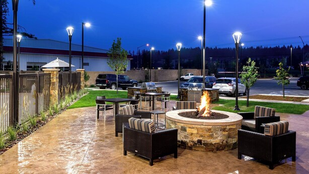 Un patio al aire libre con asientos, una chimenea y farolas.
