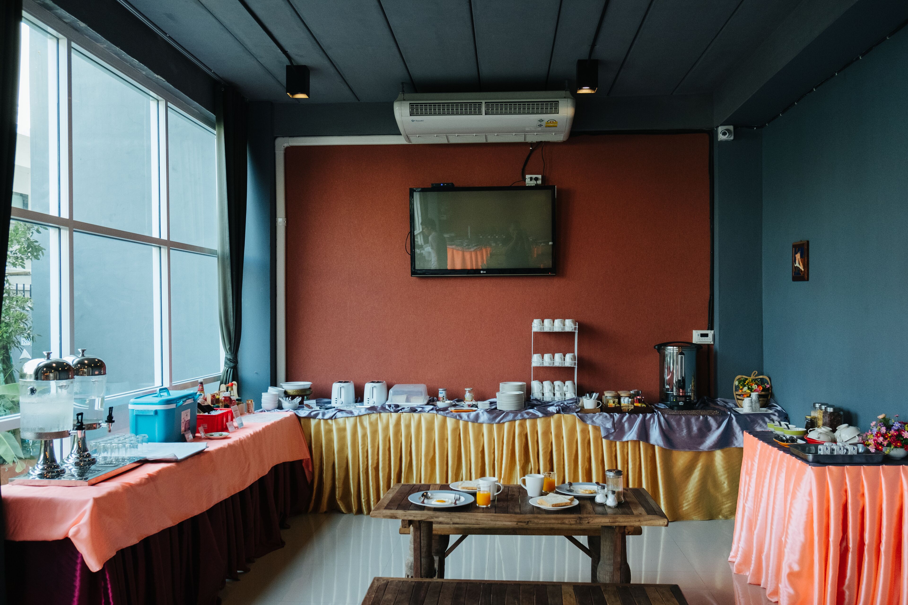 A breakfast setup with a table, chairs, and a TV mounted on the wall.